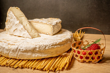 Cheese Camambert with raspberry basket. Rustic set on black backdrop. Healthy fresh nutrition. Healthy food background.
