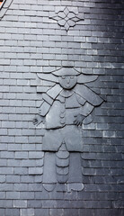 Outline of a person sculpted in slate roofing tiles