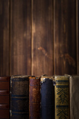 Old books on wooden shelf. Bookshelf history theme grunge background.