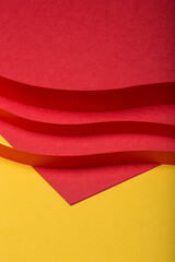 Abstract minimal paper background. Three red cut out paper stripes on red and yellow paper background.