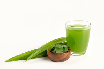 Pandan juice in glass with pandan slice  and leaves in wooden bowl on white background.