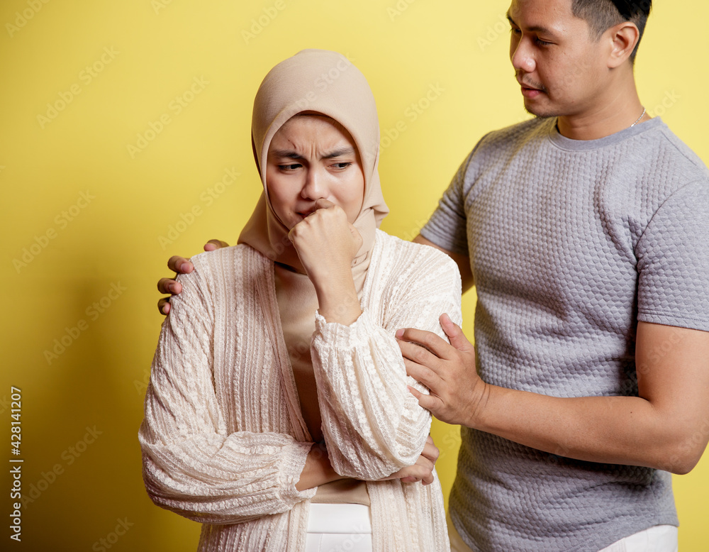 Wall mural portrait of a sad woman a man calms a woman. Patience everything will be fine. isolated on yellow background