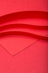 Abstract minimal paper background. Three red cut out paper stripes on red paper background.
