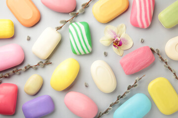 Obraz premium Different white soaps with flowers. A lot of solid soap for hygiene and cleanliness on a grey background.
