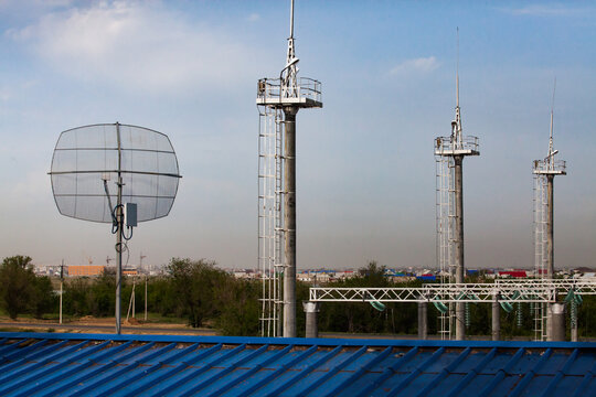 Modern gas power station. Three lighting masts with lightning arresters (lightning rod) on blue sky. Radio antenna on foreground. Oral (Uralsk) city, Kazakhstan.