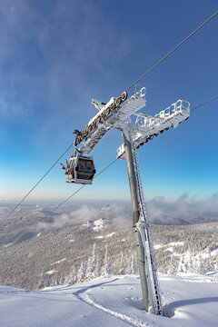 The Support Of The Ski Lift On The Background Of The Mountain Valley And The Cabin With The Ski Staff Goes Up