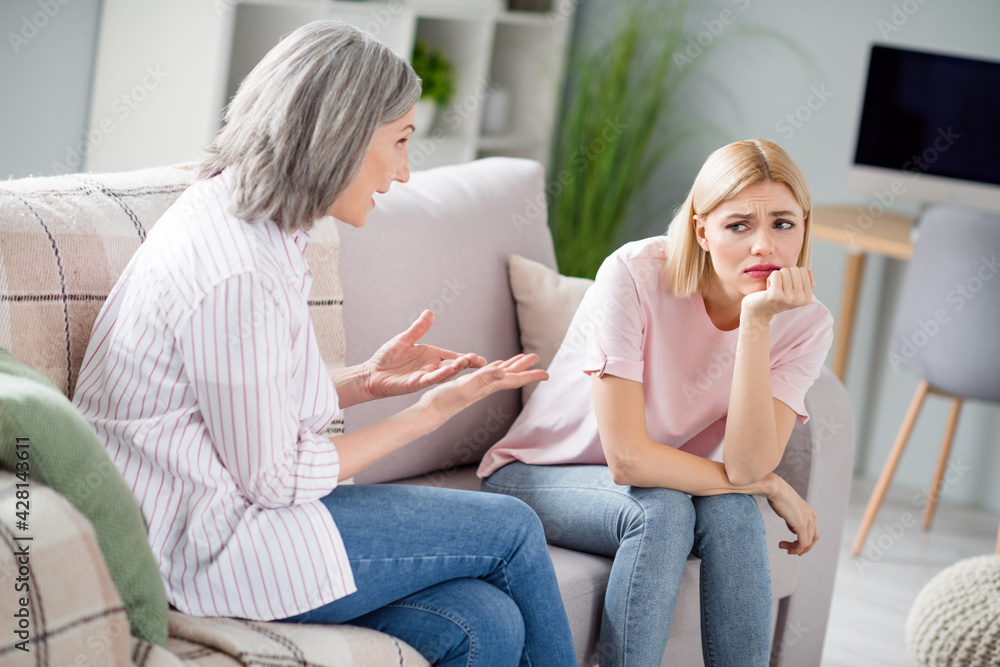 Sticker Photo of two persons sit on couch hand under chin bad mood mother tech speak hands palms show home indoors