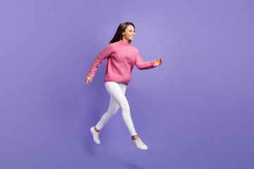 Full size photo of happy smiling cheerful beautiful woman running in air look copyspace isolated on purple color background