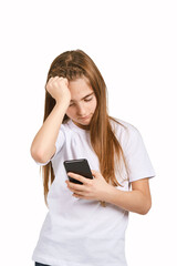 Fototapeta premium Children portrait in white t-shirt. Studio isolated concept. Girl with black smartphone. Bored emotion