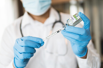 Close up of doctor holding vaccine and syringe, concept of medical for vaccine anti coronavirus, selective focus.