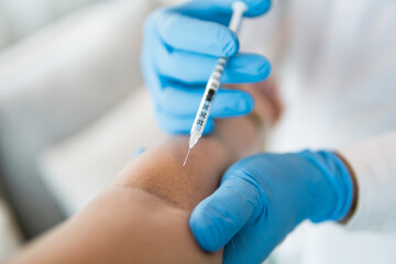 The doctor is injecting close up
