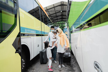 happy asian muslim holiday trip riding a bus together with family wearing mask preventing virus spread