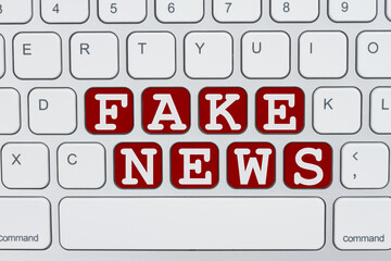 Fake News on the internet message on a gray keyboard