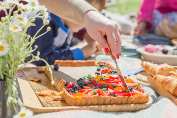 Picnic setting with picnic food, picnic hamper basket, guitar and food ready for party