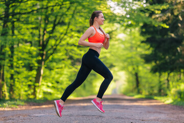 Young athletic girl with long hair in a pink sports top training