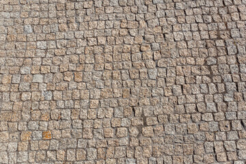 Standard view of granite sidewalk with irregular pairing, characteristic texture with moss in the joints