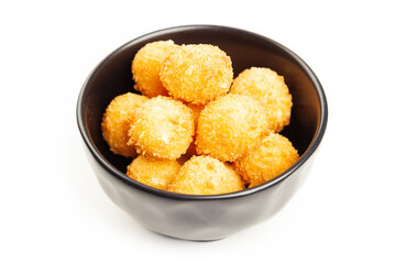 Cheese balls in a black bowl isolated on white from above. Puffed golden cheese balls as classic kids snack on wooden background