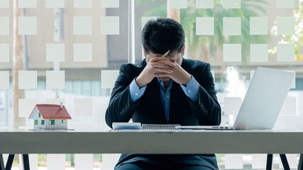 Real estate business man I'm sad, anxious About the cost of A bad company in an office with a...
