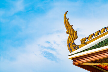 Fototapeta na wymiar BANGKOK, THAILAND - April 14, 2021: Golden Naga structure pattern on ornamental Thai temple roof against blue sky background in Golden Mount or Wat Saket Golden Mountain Temple famous.