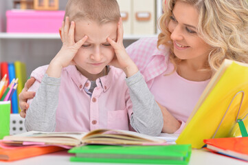 Fototapeta premium Mother with her son doing homework at home