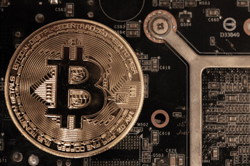 Bitcoins lie on the video card, concept of mining. Electronic virtual money for web banking and international network payment. Symbol of crypto currency. High quality photo