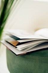 The magazine is open with white pages, lying on a chair made of modern fabric. Office furniture, copy space.
