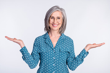Portrait of attractive cheerful middle-aged lady demonstrating holding on palms copy space ad isolated over gray light pastel color background