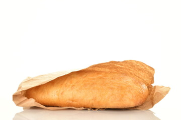 One fresh fragrant ciabatta in a paper bag, close-up, isolated on white.