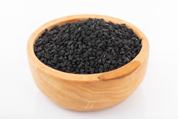 Black cumin seeds. Black cumin in wooden bowl on white background. nigella sativa, black sesame, black cumin,