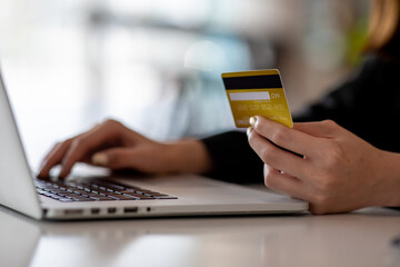 Fototapeta premium Close up woman hand using credit card and smartphone laptop for buying online shopping