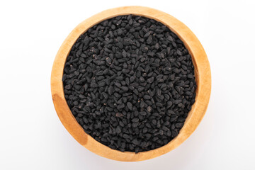 Black cumin seeds. Black cumin in wooden bowl on white background. nigella sativa, black sesame, black cumin,