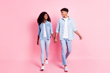 Full size photo of handsome guy attractive dark skin lady look each other hold arms isolated on...