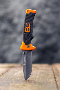 Ukraine, Khmelnytsky region, April 2021. Hunting knife stuck in a board on a dark background