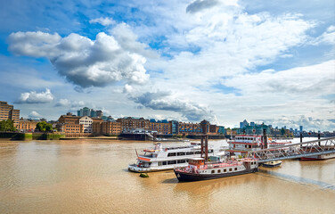 River Thames in East London on a bright sunny day with passenger boats on the foreground. Wappping...