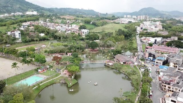 An aerial shot of a green city with a beautiful lake and recreational park in 4K