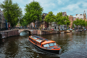 Fototapeta na wymiar Amsterdam view - canal with boad, bridge and old houses