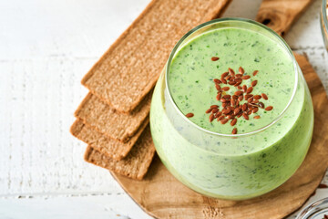 Detox green smoothie with kale, spinach and kiwi on a light gray slate, stone or concrete background. Top view with copy space.