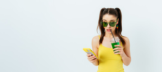Attractive young woman wearing summer outfit and sunglasses holding mobile phone