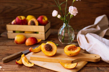 sliced nectarines on a chopping board on a wooden table. halves and slices of sweet peach in the kitchen