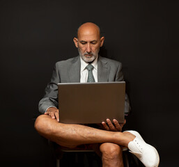 ejecutivo con pantalón corto y zapatillas con el ordenador