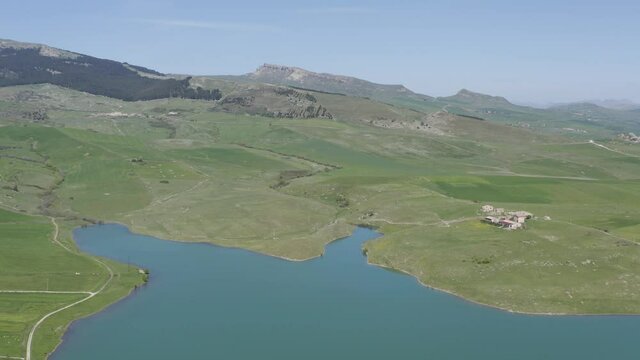 Lake Prizzi in the heart of the Sicani mountains in Sicily. Lush vegetation with wheat crops. Rurality in Sicily. Green in Sicily in spring. Relax by the lake. Migratory birds.