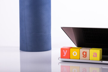 yoga mat with laptop computer ready for an online class or classes with lettering yoga