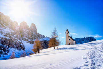 Wolkenstein in Gröden in winter with chapel and view to the pizes de cir, Dolomite, Italy