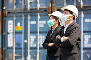 portrait businessman and businesswoman wearing medical mask and crossed arms pose with containers warehouse storage