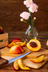 sliced nectarines on a chopping board on a wooden table. halves and slices of sweet peach in the kitchen