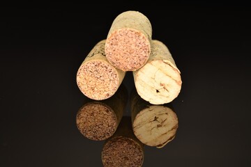 Three wine corks, close-up, on a black background.