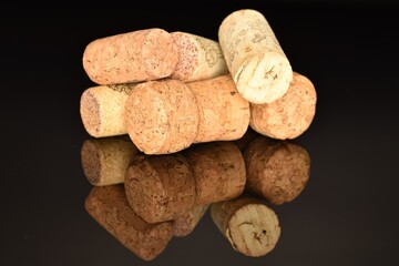 Several wine corks, close-up, on a black background.