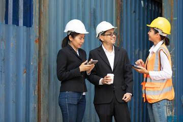 businessman and businesswoman talking with woman engineer in containers warehouse storage