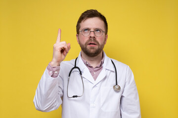 Strange doctor raised index finger and eyes upward, he thought and tried to remember something. Yellow background.