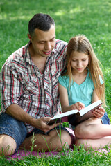 young father with a  daughter reading the Bible